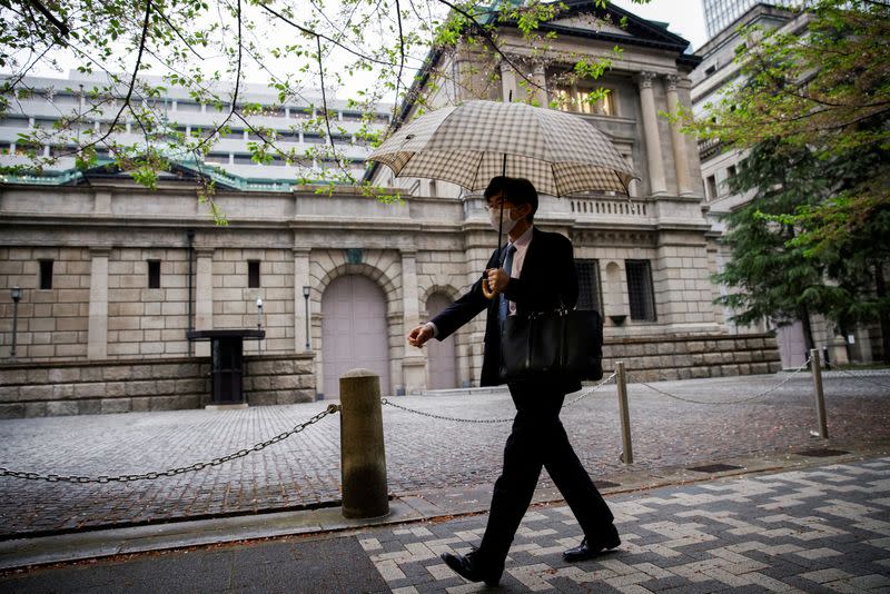 FILE PHOTO: Office employee walks in front of the bank of Japan building in Tokyo