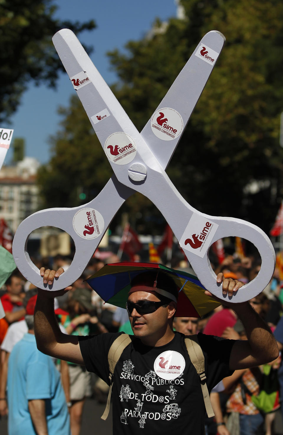 A man hold scissors in protest against austerity measures applied by the Spanish government, in Columbus Square in Madrid, Spain, Saturday, Sept. 15, 2012. Tens of thousands of people from all over the country converged on Madrid to hold a large anti-austerity demonstration on Saturday. By mid-morning several major roads had been blocked as buses unloaded protesters at 10 rendezvous points from which marches began.The demonstration was called to protest government cuts during the country's financial crisis. (AP Photo/Andres Kudacki)