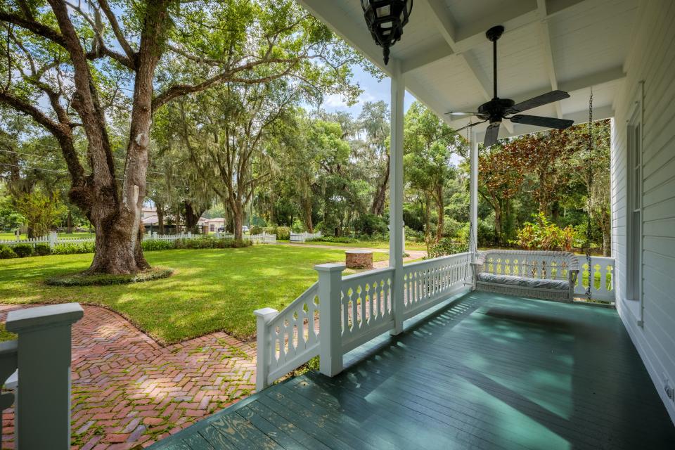 The front porch, looking out on Mandarin Road in the distance, along with an ancient oak tree that was most likely a sapling when John C. Brown built his farmhouse in 1880.