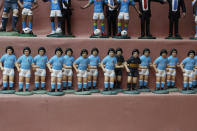 Statuettes of soccer legend and former Napoli player Diego Armando Maradona are displayed on the counter of a stall selling nativity scenes in Via San Gregorio Armeno, downtown Naples, Italy, Wednesday, Sept. 18, 2019. “One of the first figurines we made was of Diego Armando Maradona and you can imagine how many we sold. Still today, it sells a lot,” said craftsman Marco Ferrigno, who runs the most prominent shop on the street. (AP Photo/Gregorio Borgia)