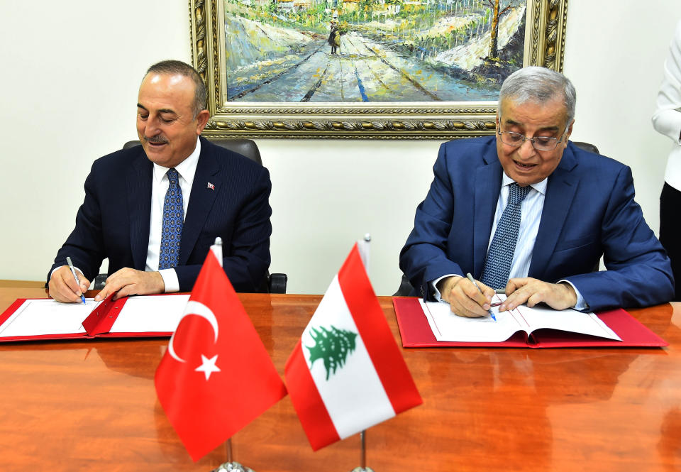 In this photo released by Lebanon's official government photographer Dalati Nohra, Turkey's Foreign Minister Mevlut Cavusoglu, left, signs agreements between the two countries with his Lebanese counterpart Abdallah Bou Habib, at the Lebanese foreign ministry, in Beirut, Lebanon, Tuesday, Nov. 16, 2021. (Dalati Nohra via AP)