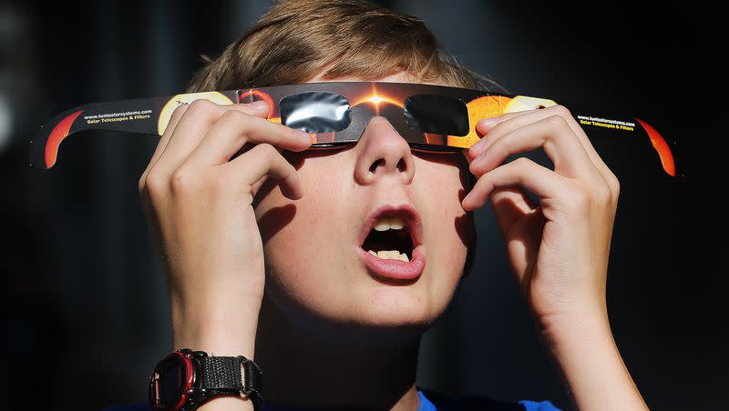 Colton Hammer tries out his new eclipse glasses he just bought from the Clark Planetarium in Salt Lake City on Wednesday, Aug. 16, 2017.