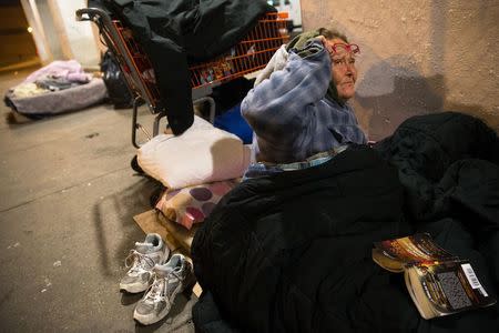 Teresa Sigerson, 51, has a conversation with a fellow homeless person before going to sleep at the overpass under which she sleeps in Chicago, December 4, 2014. Sigerson has been living under the overpass for 3 years. REUTERS/Andrew Nelles