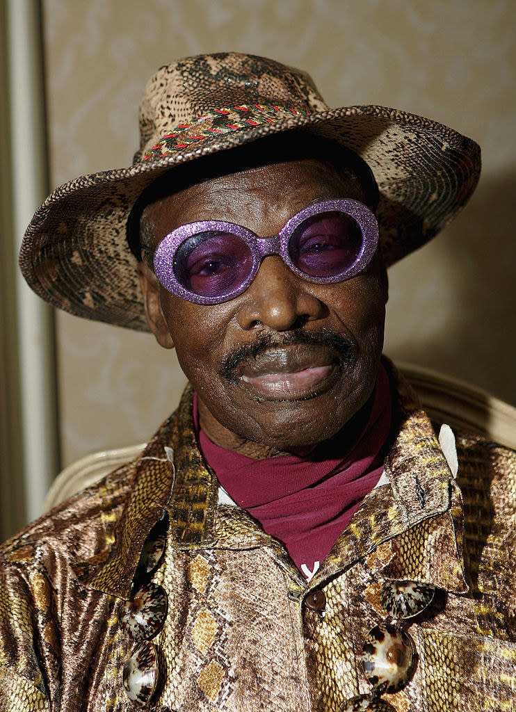 Rudy with colorful circular glasses and a bucket hat