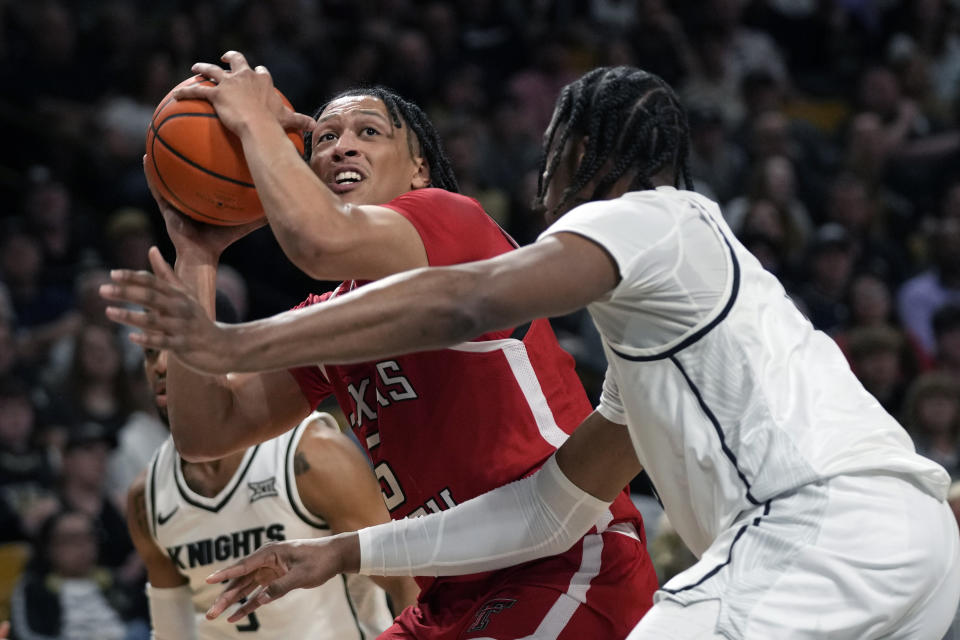 Texas Tech guard Darrion Williams, left, looks to shoot against Central Florida forward Omar Payne during the first half of an NCAA college basketball game, Saturday, Feb. 24, 2024, in Orlando, Fla. (AP Photo/John Raoux)