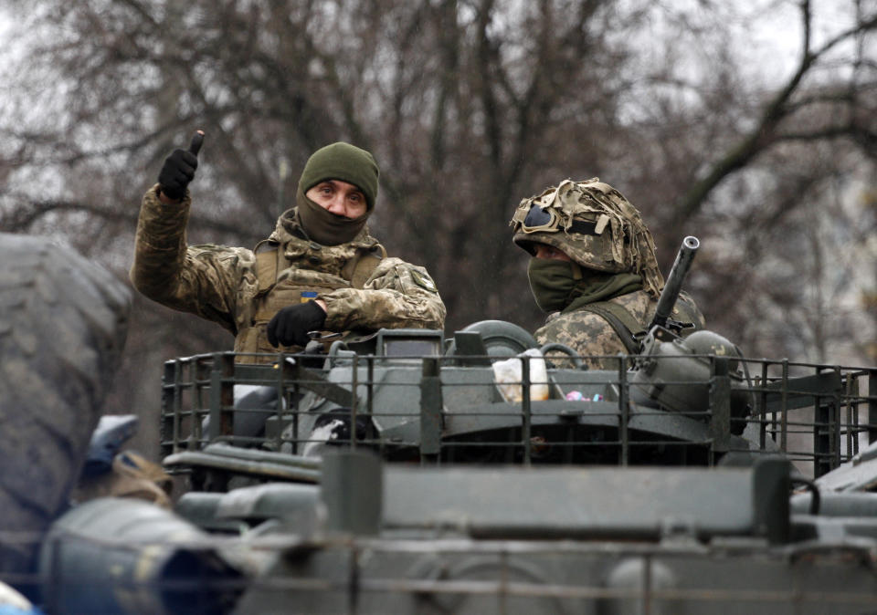 A Ukrainian serviceman gives a thumbs-up riding atop a military vehicle before an attack in the Lugansk region.