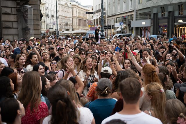 <p>Thomas Kronsteiner/Getty</p> Taylor Swift fans sing together on August 08, 2024 in Vienna, Austria, following failed terror plot