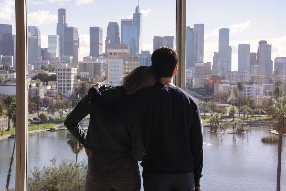 Hannah Einbinder and Paul W. Downs in 'Hacks' stare out at the skyline of Los Angeles, their backs to the camera. 