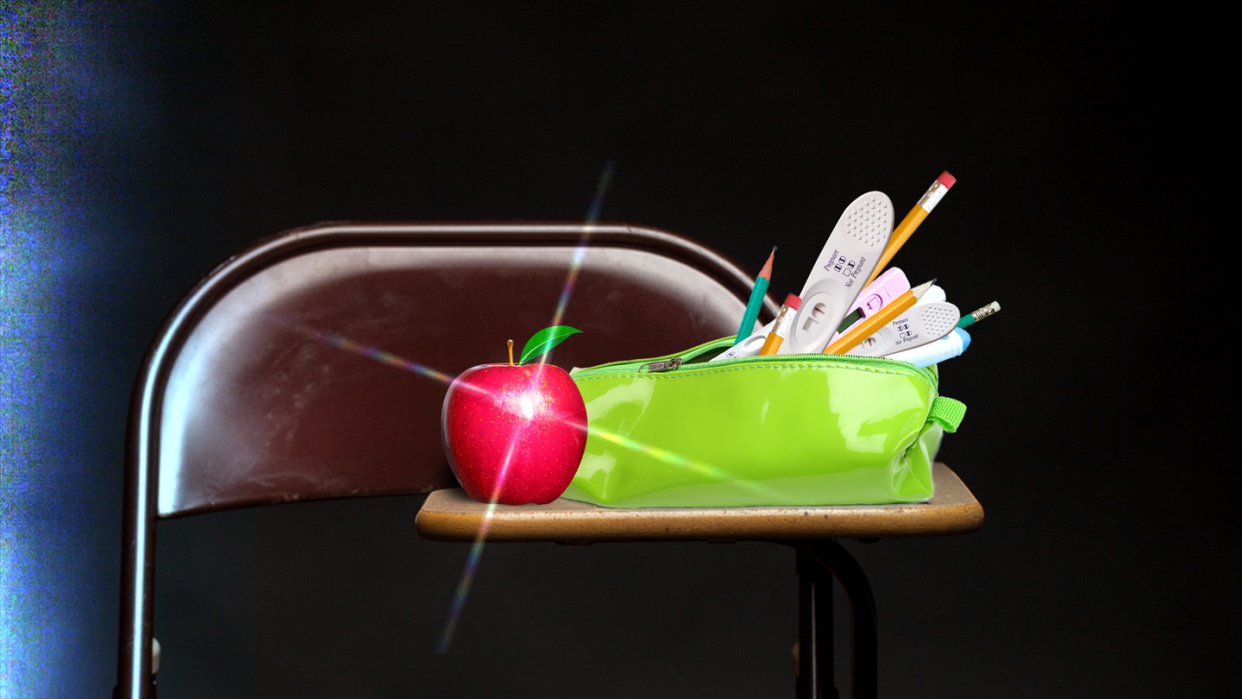 a fertility kit spilling out of a green pencil bag on a classroom desk