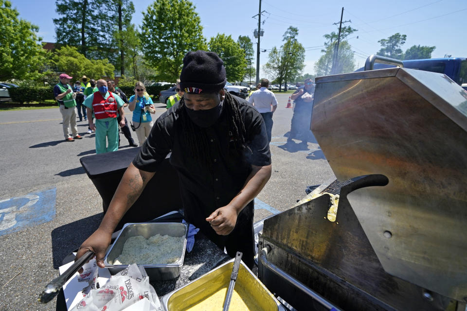 FILE - In this March 29, 2021, file photo, Ryan "Kool Aid" Hurst of Drago's Restaurant, serves char-grilled oysters to health care workers at "Vaccine Fest," a 24-hour COVID-19 mass vaccination event in Metairie, La., just outside New Orleans, hosted by Ochsner Health System and the Jefferson Parish Government. Louisiana is making a full-court press to get shots in arms, with sometimes creative outreach to make it as easy as possible to get vaccinated.(AP Photo/Gerald Herbert, File)