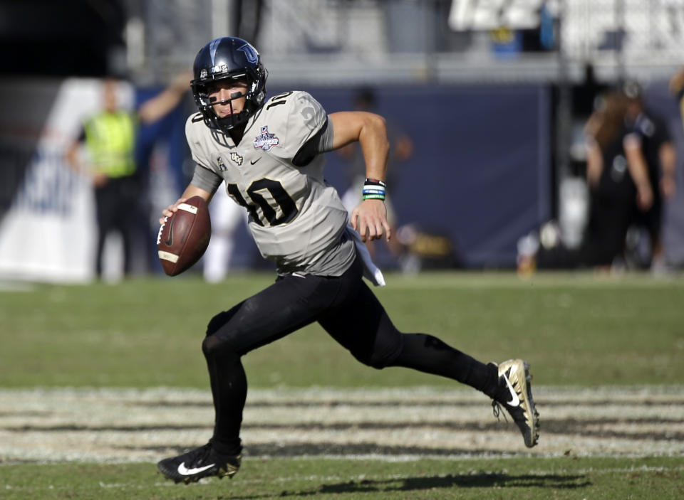 File- This Dec. 2, 2017, file photo shows Central Florida quarterback McKenzie Milton scrambles during the second half of the American Athletic Conference championship NCAA college football game against Memphis, in Orlando, Fla. Milton returns for his junior season after leading Central Florida to an undefeated season in 2017. Milton threw for 4,037 yards and 37 touchdowns. All four of the quarterbacks are from Oahu and have a lot of common connections. Milton said they’ve all trained together or played against each other, whether in high school games or in more informal settings like camps. Both Mariota and Milton credited Vince Passas _ the quarterbacks coach at St. Louis School in Honolulu, for helping develop Hawaii’s quarterback talent. (AP Photo/John Raoux, File)