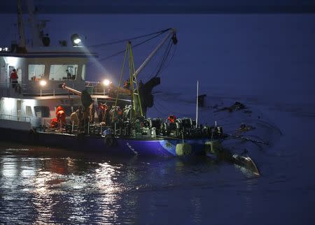 A rescue ship and workers are seen around a sunken ship in the Jianli section of Yangtze River, Hubei province, China, June 2, 2015. REUTERS/Kim Kyung-Hoon