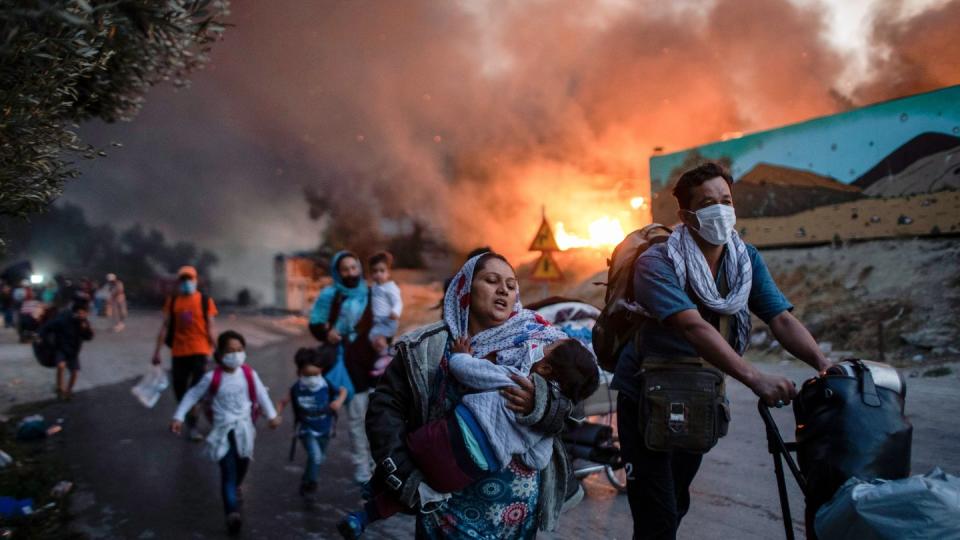 Migranten fliehen im September 2020 aus dem brennenden Flüchtlingslager Moria auf Lesbos.