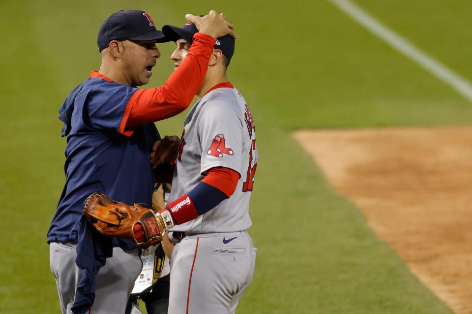 Red Sox manager Alex Cora, left, celebrates with Jose Iglesias after clinching a wild card berth on Sunday.