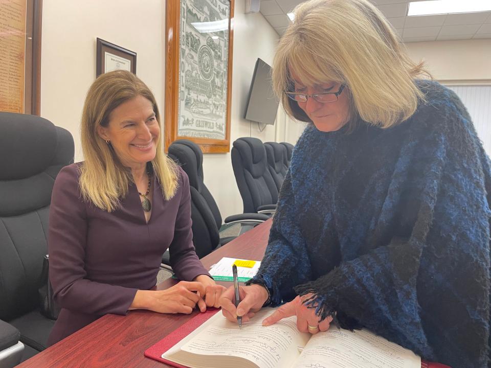 Lt. Gov. Susan Bysiewicz and Griswold First Selectwoman Tina Falck sign a ledger kept by the town clerk, making her swearing in official. All the other election winners did the same.