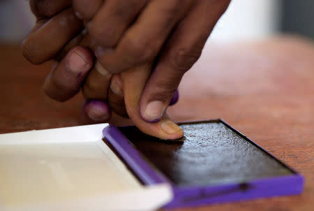 FILE PHOTO: An electoral commission official marks with ink the thumb of a voter after casting his ballot during the presidential election at a polling centre in Analakely, Antananarivo, Madagascar November 7, 2018. REUTERS/Malin Palm/File Photo