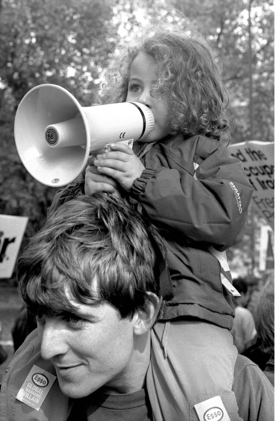 Loud and proud: A little boy perched on top of his father’s shoulders pleading for the prevention of an impending war on Iraq