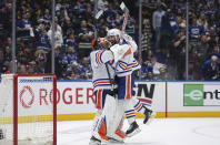 Edmonton Oilers' Evan Bouchard, right, and goalie Stuart Skinner celebrate after Edmonton defeated the Vancouver Canucks 3-2 during Game 7 of an NHL hockey Stanley Cup second-round playoff series, in Vancouver, British Columbia, on Monday, May 20, 2024. (Darryl Dyck/The Canadian Press via AP)