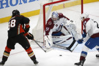 Colorado Avalanche goalie Philipp Grubauer (31) and forward Nathan MacKinnon (29) defend as Anaheim Ducks forward Derek Grant (38) shoots during the second period of an NHL hockey game in Anaheim, Calif., Friday, Jan. 22, 2021. (AP Photo/Ringo H.W. Chiu)