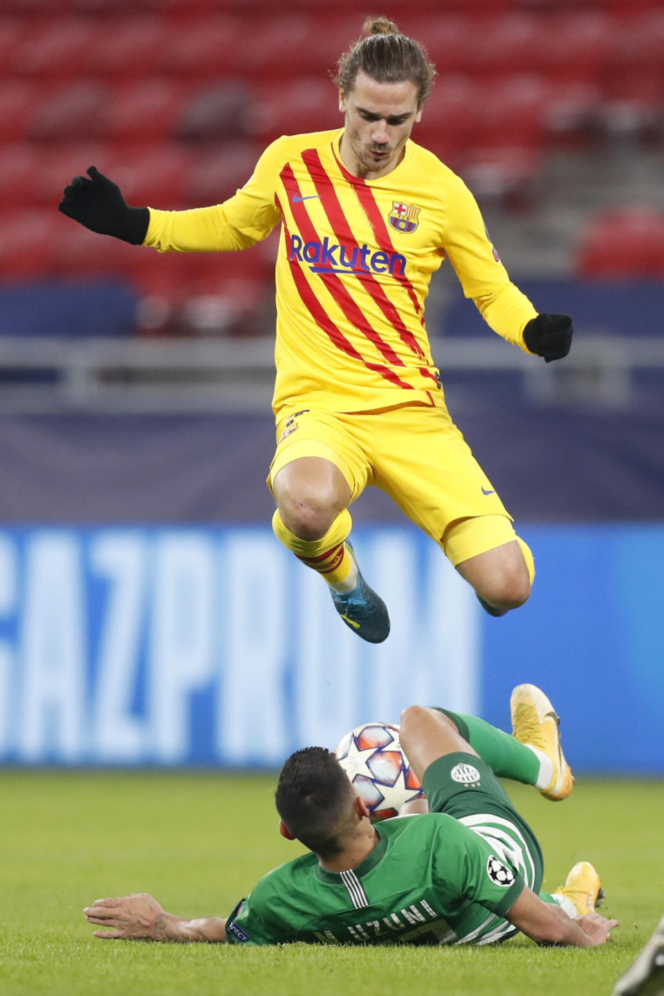 Barcelona's Antoine Griezmann is tackled by Ferencvaros' Myrto Uzuni during the Champions League group G soccer match between Ferencvaros and Barcelona at the Ferenc Puskas stadium in Budapest, Hungary, Wednesday, Dec. 2, 2020. (AP Photo/Laszlo Balogh)