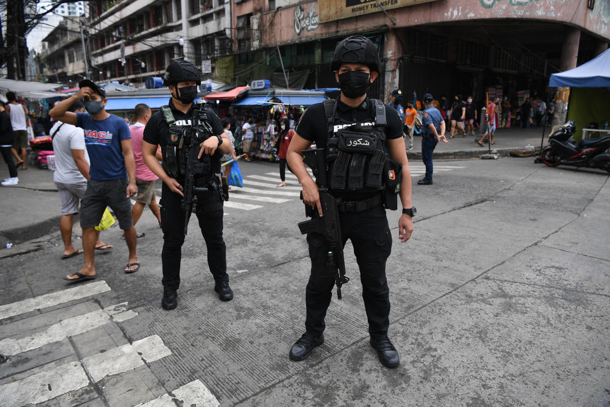 Members of police Special Weapons and Tactics (SWAT) stand guard along a popular market street in Manila on June 1, 2022, as security forces are on heightened alert in the capital following the twin bombings in Basilan island, near Jolo, a stronghold of Muslim militants. (Photo by Ted ALJIBE / AFP) (Photo by TED ALJIBE/AFP via Getty Images)
