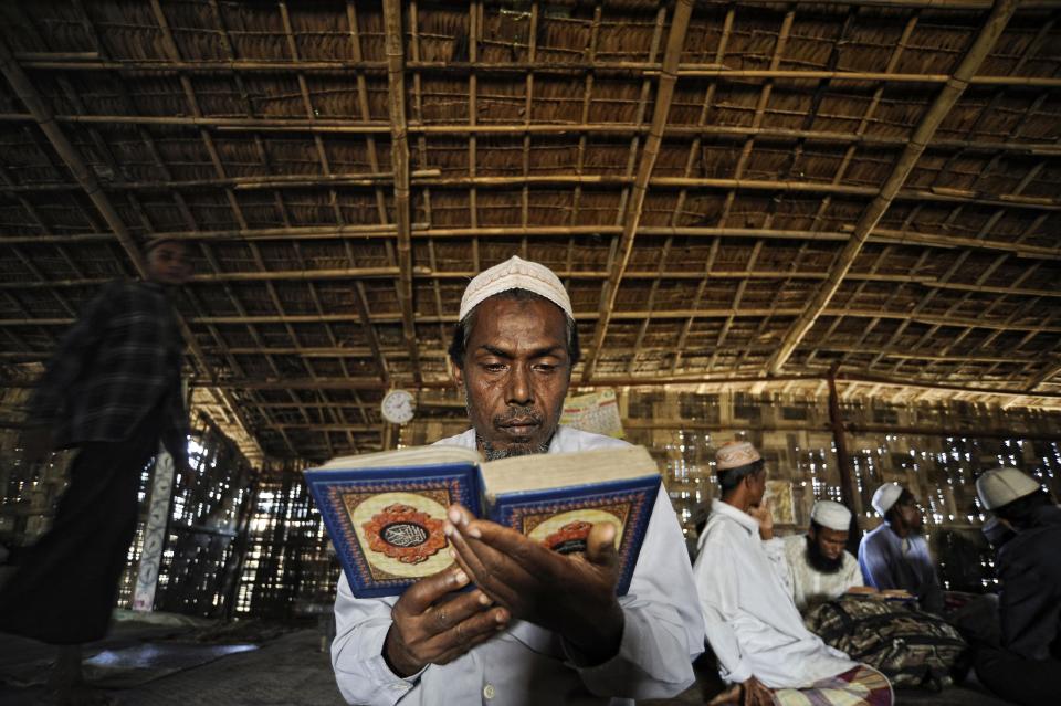 In this Nov. 30 2013 photo, Mohamad Iris, father of Senwara and Mohamad, prays at a makeshift mosque at the Ohn Taw refugee camp on the outskirts of Sittwe, Myanmar. After his tiny Muslim village in Myanmar's northwest Rakhine had been destroyed in a fire set by an angry Buddhist mob, the two children, 9- and 15-years old, became separated from the family. (AP Photo/Kaung Htet)