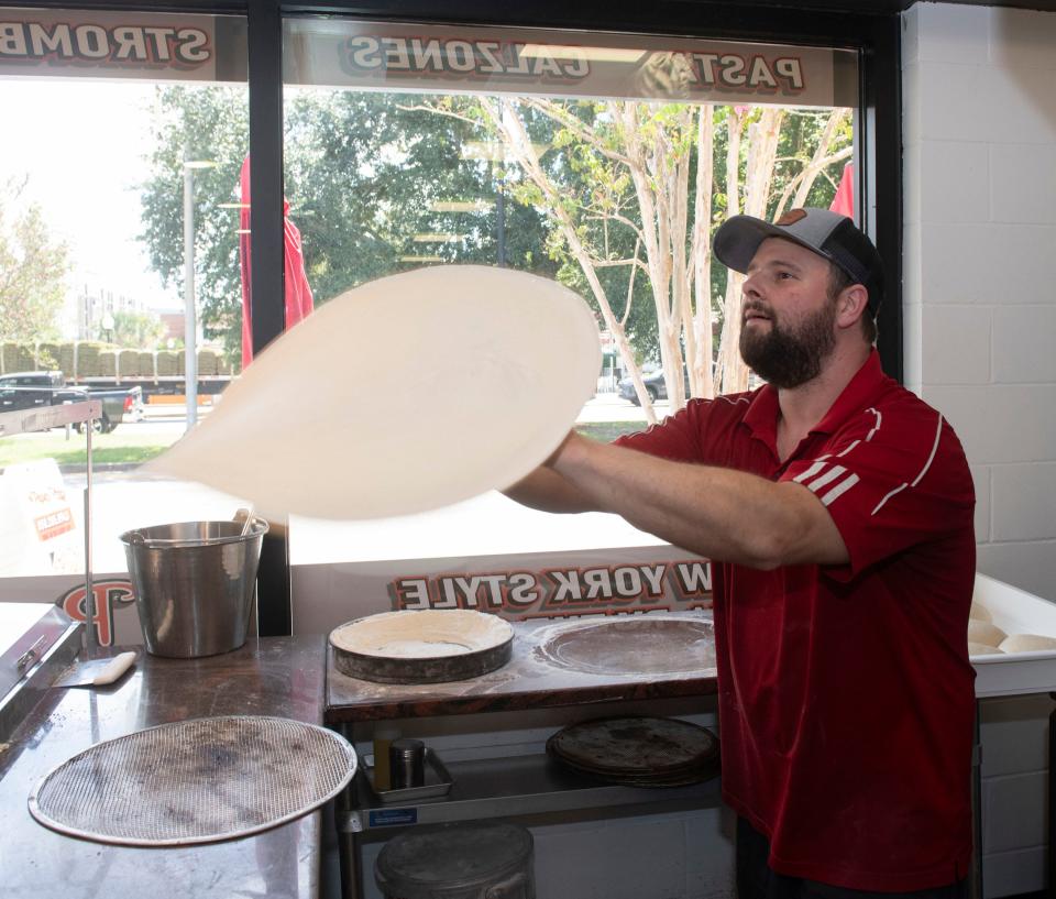 Nick Burleigh hand-tosses the dough for a fresh pie at the Papa's Pizza location in downtown Pensacola on Tuesday, Sept. 26, 2023.