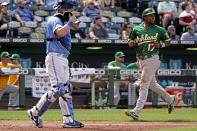 Oakland Athletics' Elvis Andrus (17) runs home past Kansas City Royals catcher MJ Melendez (1) to score on a double by Nick Allen during the fourth inning of a baseball game Saturday, June 25, 2022, in Kansas City, Mo. (AP Photo/Charlie Riedel)