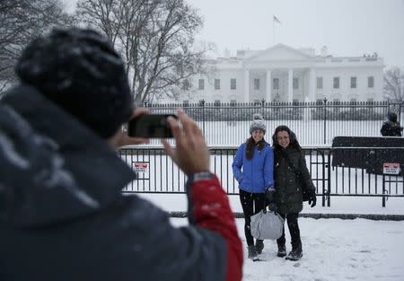 People pose for pictures in the freshly fallen snow outside the White House in Washington January 22, 2016. REUTERS/Jonathan Ernst