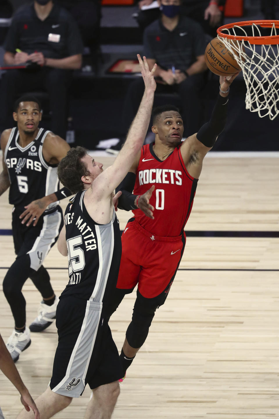 Houston Rockets guard Russell Westbrook (0) goes up for a shot past San Antonio Spurs center Jakob Poeltl (25) during the first half of an NBA basketball game Tuesday, Aug. 11, 2020, in Lake Buena Vista, Fla. (Kim Klement/Pool Photo via AP)