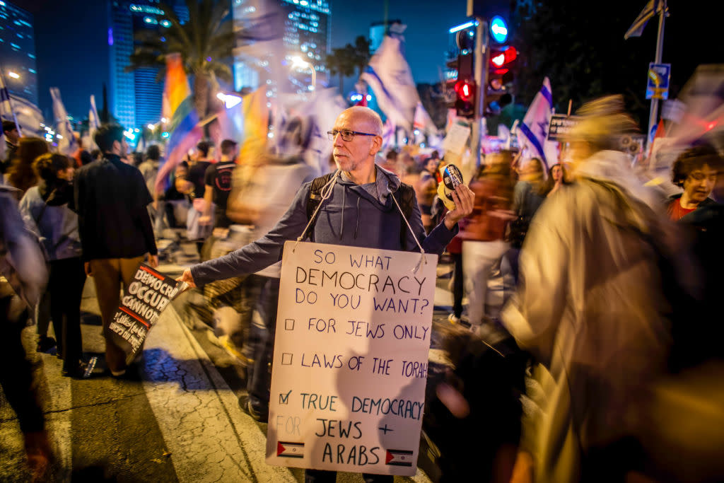 A protester holds placards expressing his opinions during