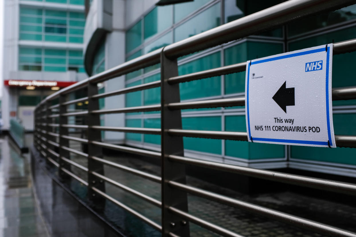 A sign directs patients towards an NHS 111 Coronavirus (COVID-19) Pod, where people who believe they may be suffering from the virus can attend and speak to doctors, at London University Hospital in London on March 5, 2020.  (Photo by Alberto Pezzali/NurPhoto via Getty Images)