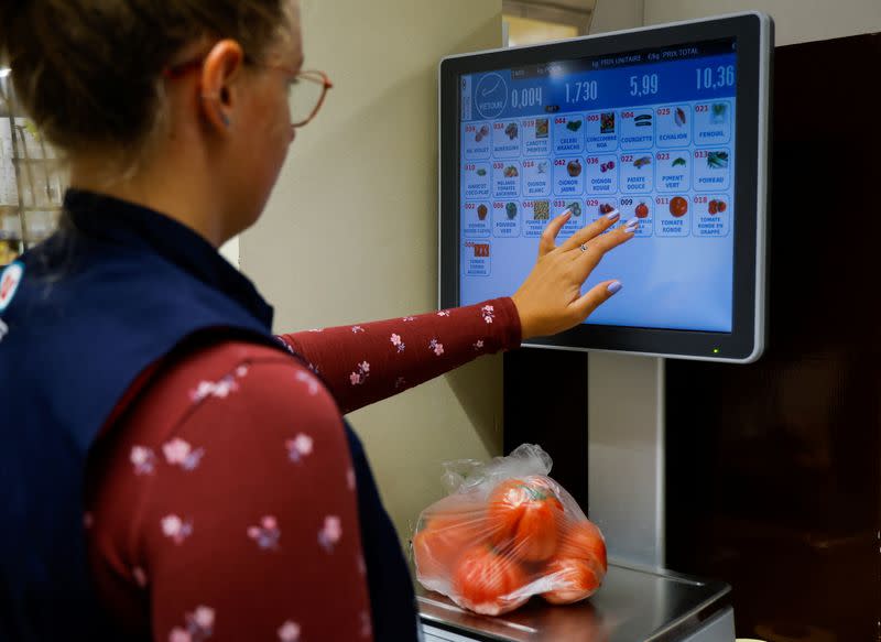 An employee weighs vegetables in a supermarket in Nice