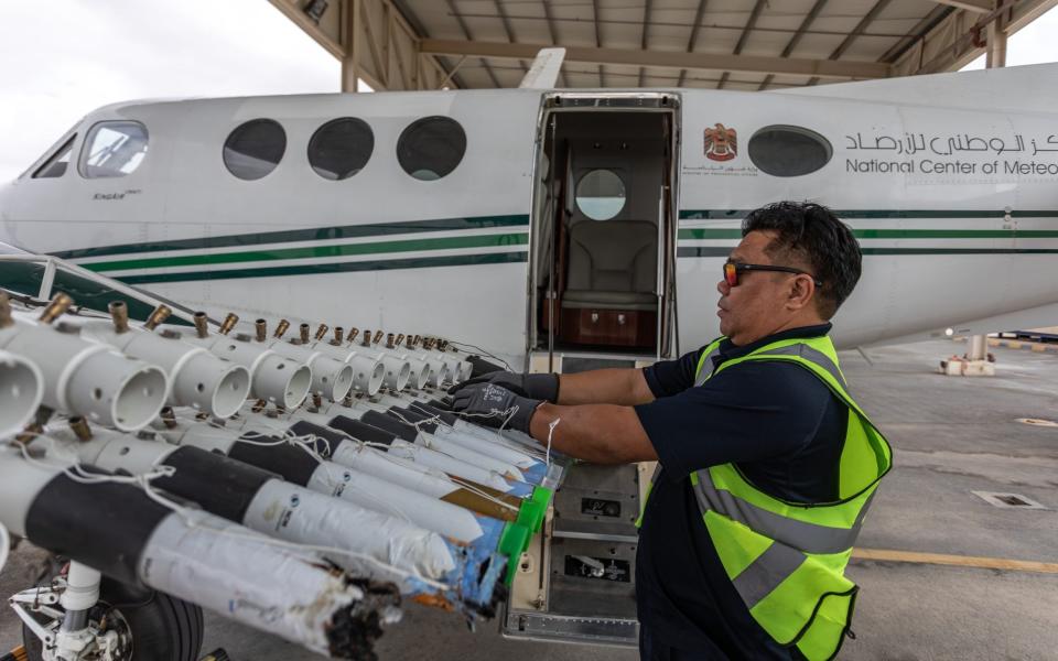 A ground engineer supplementing one of the UAE National Center of Meteorology's cloud seeding planes with new hygroscopic salt flares