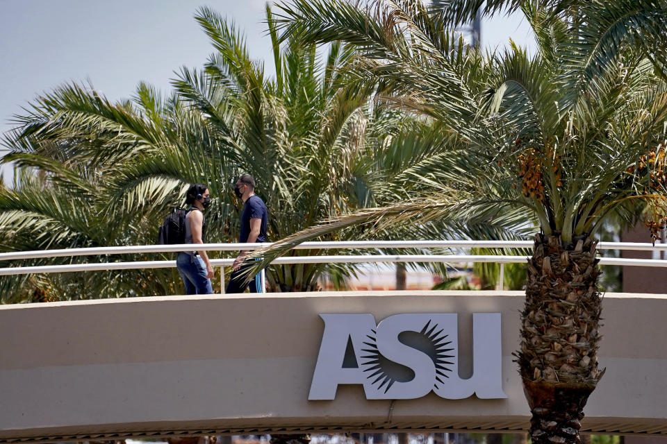 People use a footbridge over University Avenue on the campus of Arizona State University on Tuesday, Sept. 1, 2020, in Tempe, Ariz. Officials in college towns all over the U.S. are fretting that off-campus students are being counted in places other than the communities where their schools are located. (AP Photo/Matt York)