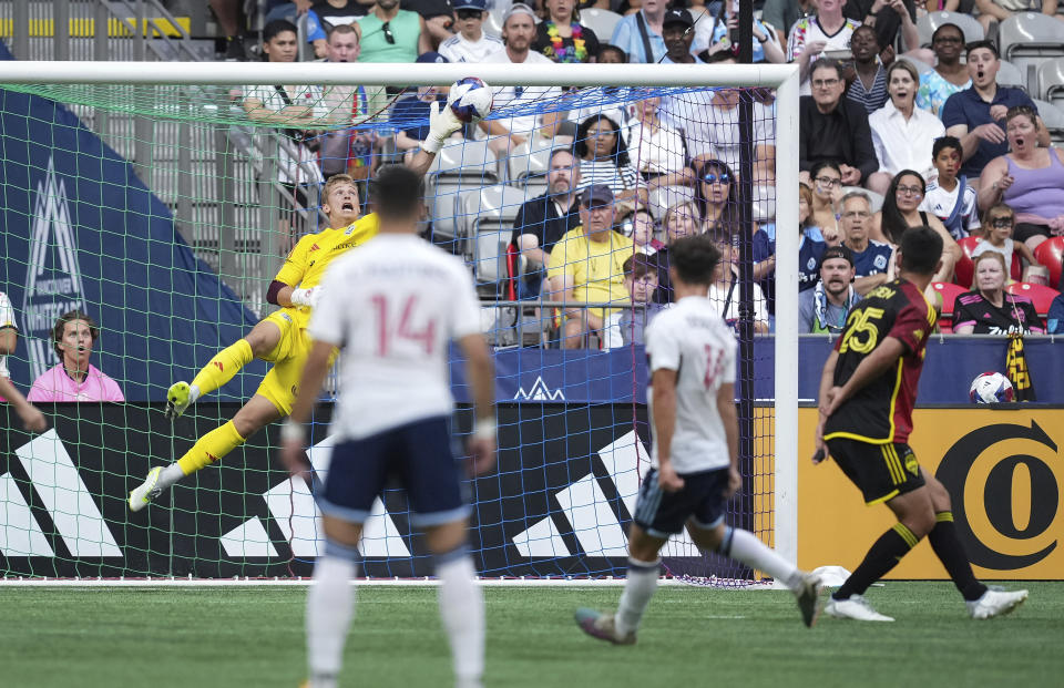 Seattle Sounders goalkeeper Stefan Cleveland, back left, stops a shot from Vancouver Whitecaps' Luis Martins, second from right, during the first half of an MLS soccer match Saturday, July 8, 2023, in Vancouver, British Columbia. (Darryl Dyck/The Canadian Press via AP)