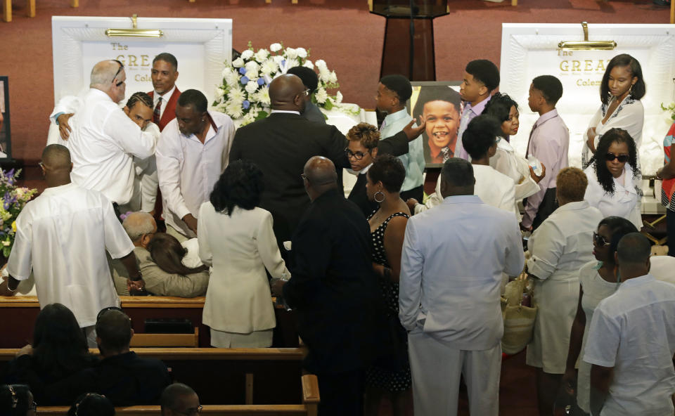 Guest comfort each other during the showing of Glenn Coleman, Reece Coleman, Evan Coleman and Arya Coleman, Friday, July 27, 2018, in Indianapolis. Nine members of the Coleman family were killed after a duck boat capsized and sank during a storm in Branson, Mo. (AP Photo/Darron Cummings)
