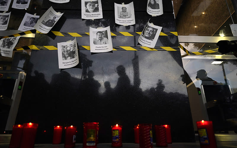 Photos of slain journalists are posted up on a wall