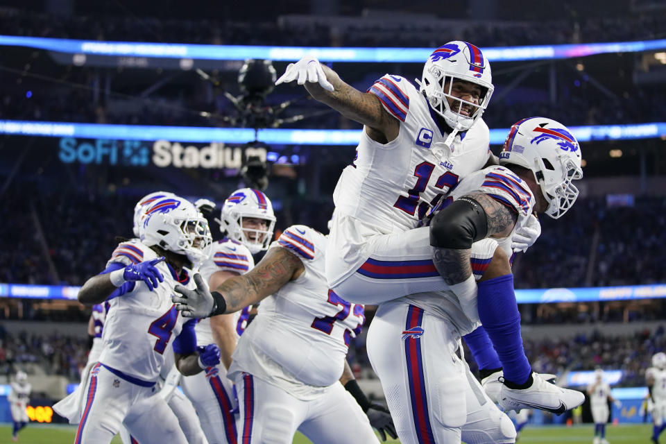 Buffalo Bills wide receiver Gabe Davis (13) is lifted by offensive tackle Spencer Brown (79) after Davis' touchdown reception against the Los Angeles Chargers during the first half of an NFL football game Saturday, Dec. 23, 2023, in Inglewood, Calif. (AP Photo/Ashley Landis)