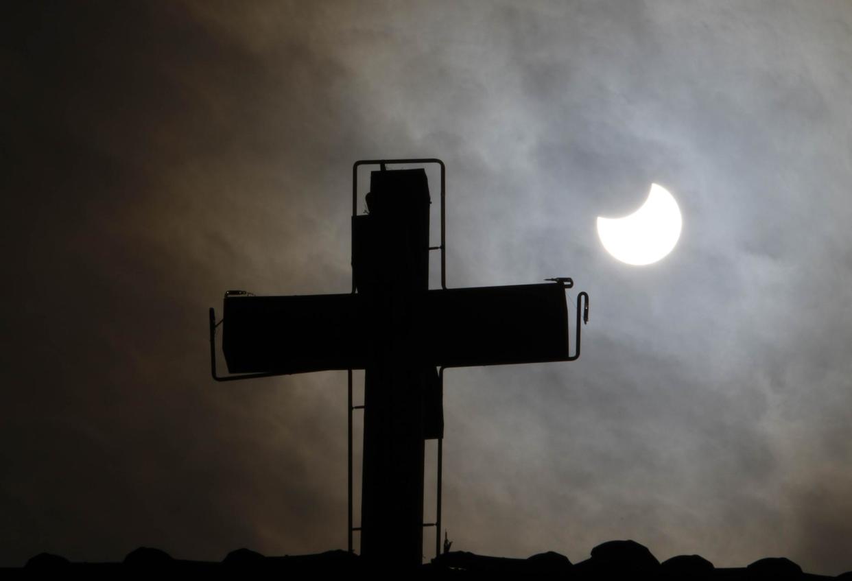 A picture taken on January 4, 2011 in Old Damascus shows the world's first partial solar eclipse of 2011 behind the cross of a church in a Christian neighbourhood of the Syrian capital: LOUAI BESHARA/AFP/Getty Images