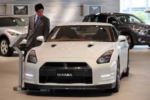 A businessman look at car at the showroom of the Nissan headquarters in Yokohama, suburban Tokyo. Nissan on Friday posted a $4.28 billion full-year net profit and record sales as the Japanese automaker shrugged off the devastating impact of last year's quake-tsunami disaster on production