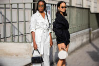 Chrissy Rutherford is seen wearing a pair of white overalls and Anna Rosa Vitiello wearing black overalls with a white bag. [Photo: Getty Images]