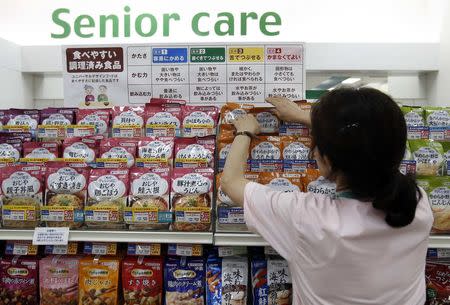 A staff arranges Kewpie Corp's nursing care food packages on a display shelf at an Ito-Yokado shopping centre in Tokyo August 5, 2014. REUTERS/Yuya Shino
