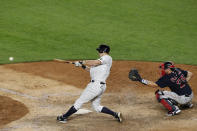 New York Yankees DJ LeMahieu hits an eighth-inning single next to Boston Red Sox catcher Kevin Plawecki during a baseball game Sunday, Aug 2, 2020, in New York. (AP Photo/Kathy Willens)