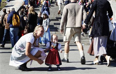 Anja List and her one-year old daughter Paulina wear traditional Bavarian Dirndls while visiting Munich's 180th Oktoberfest October 3, 2013. REUTERS/Michaela Rehle