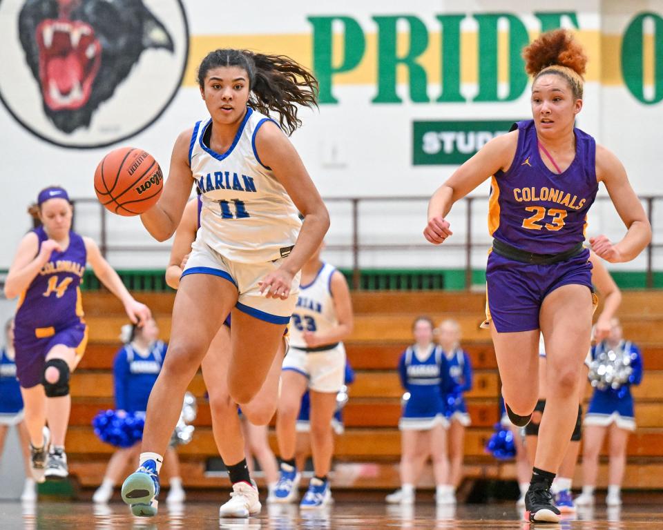 Marian’s MaKaya Porter (11) dribbles as Clay’s Myah Allen (23) defends in the first half Friday, Feb. 4, 2022, at Washington High School.