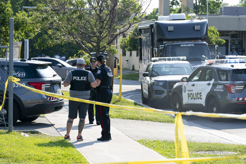 Toronto police officers investigate after several adults died in the lobby of an office space in Toronto, Monday, June 17, 2024. Police responded to reports of gunshots in an area near a school and a daycare. (Arlyn McAdorey/The Canadian Press via AP)