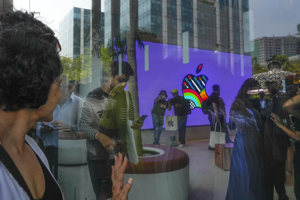 People take selfies inside the first Apple Inc. flagship store as others watch from outside, in Mumbai, India, Tuesday, April 18, 2023. Apple Inc. opened its first flagship store in India in a much-anticipated launch Tuesday that highlights the company’s growing aspirations to expand in the country it also hopes to turn into a potential manufacturing hub. (AP Photo/Rafiq Maqbool)