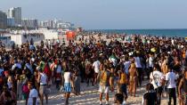 People stand in a crowd on South Beach during Spring Break in Miami Beach, Florida, on Saturday, March 18, 2023.