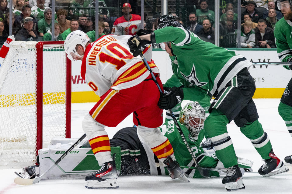Dallas Stars goaltender Jake Oettinger (29) attempts to lie out in front of the goal to stop Calgary Flames center Jonathan Huberdeau (10) from scoring during the second period of an NHL hockey game, Friday, Nov. 24, 2023, in Dallas. (AP Photo/Emil T. Lippe)